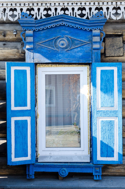Ikkuna puinen veistetty architrave vanhassa puutalossa vanhassa venäläisessä kaupungissa
. - Valokuva, kuva