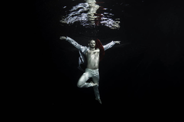 Un joven bailarín de ballet posando bajo el agua
 - Foto, Imagen