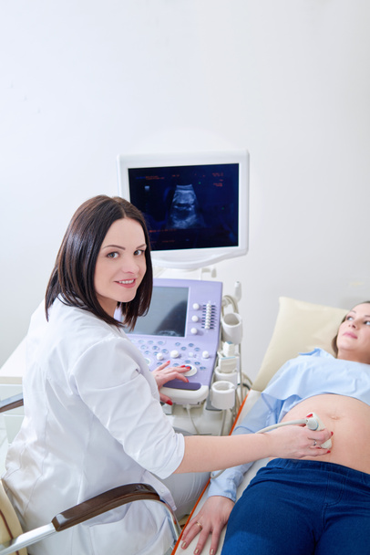 Pregnant woman having ultrasonic scanning at the clinic - Fotoğraf, Görsel
