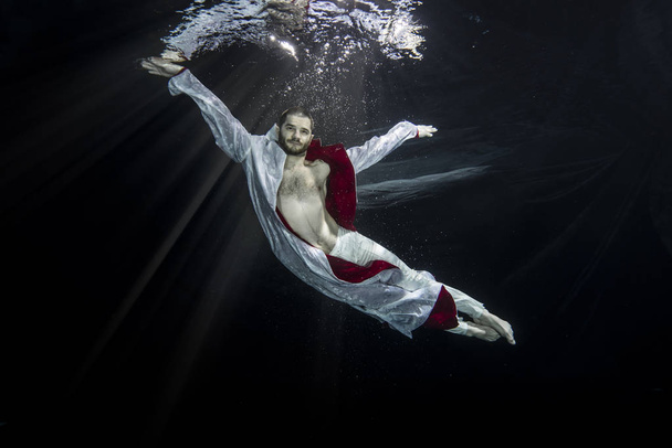 Een jonge mannelijke balletdanser poseren onderwater - Foto, afbeelding