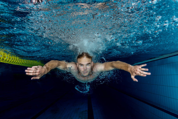 Молодий плавець плаває в басейні під водою
 - Фото, зображення