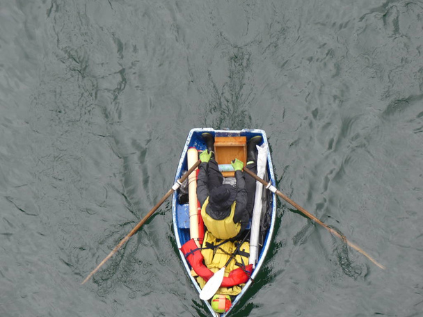 Homme assis bateau à rames vue de dessus
 - Photo, image