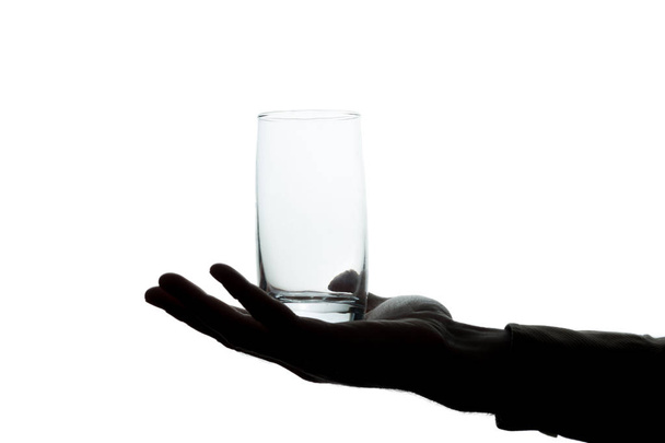 La mano del hombre con un vaso sin agua para beber - silueta
 - Foto, Imagen