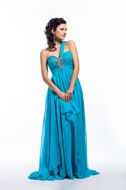Fashion woman in modern fashion long blue dress posing - Fotó, kép