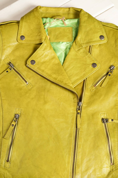 Green color leather jacket. Leather jacket macro details. Jacket zippers and pockets. Lime color leather jacket - Fotó, kép