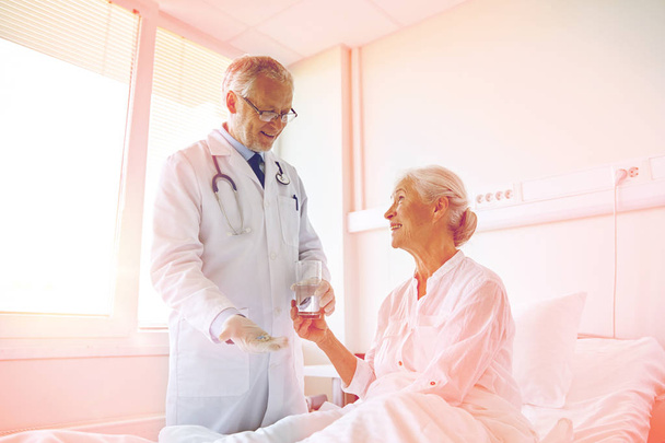doctor giving medicine to senior woman at hospital - Valokuva, kuva