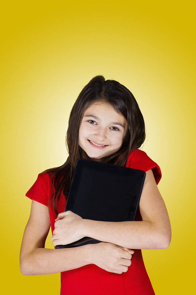 Happy smiling little girl holding tablet - Фото, изображение