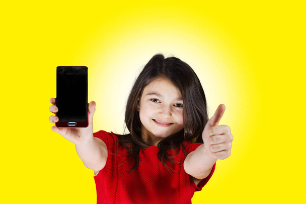 Smiling Little Girl with mobile phone - Фото, изображение