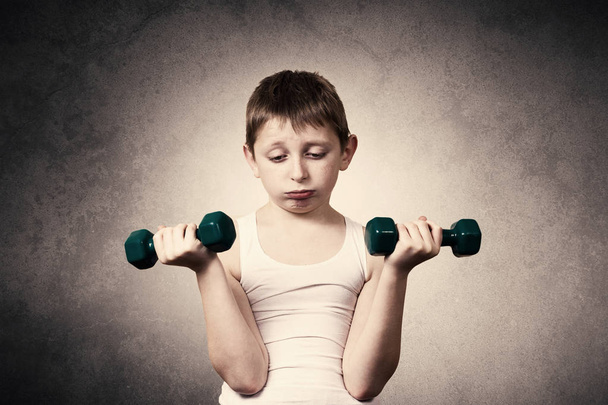 Tired,Bored,upset little boy with dumbbell.Facial expression,Sport - Foto, Imagen