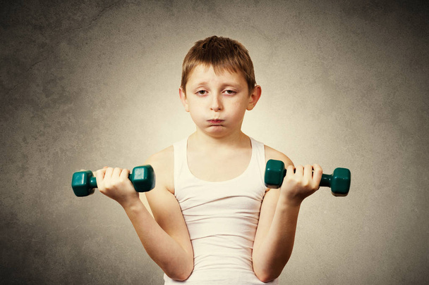 Tired,Bored,upset little boy with dumbbell.Facial expression - Фото, зображення