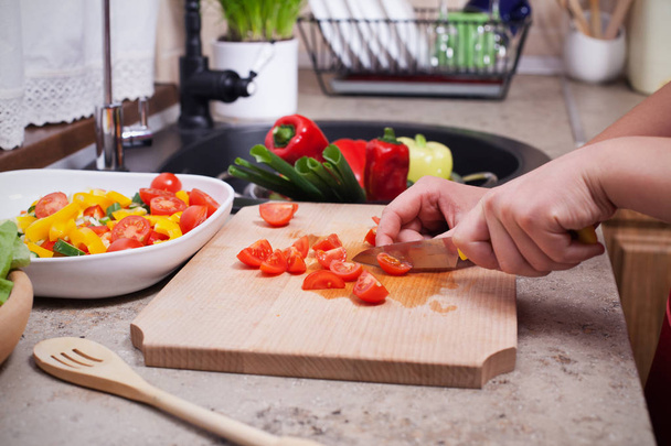 Mãos de criança cortando tomate cereja para uma salada de legumes frescos
 - Foto, Imagem