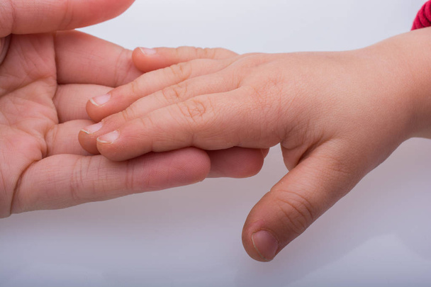 Criança e adulto mãos juntas
  - Foto, Imagem