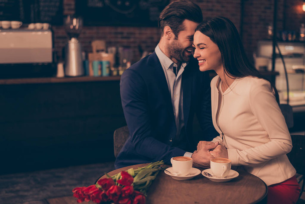 Happy romantic man and woman  sitting in a cafe with flowers dri - Фото, изображение