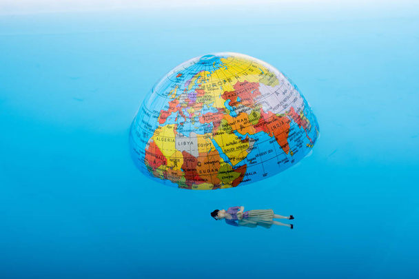 Kleine wereldbol met zwevende beeldje rond - Foto, afbeelding