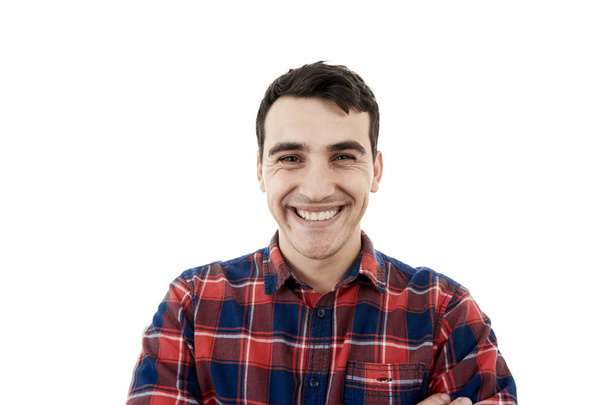 Glimlachend opgewonden jongeman geïsoleerd op een witte achtergrond. Close-up shot van Happy lachende student in shirt op witte achtergrond. - Foto, afbeelding