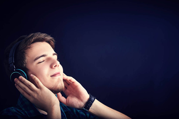 Young man student  listening  to musicand enjoying it. - 写真・画像