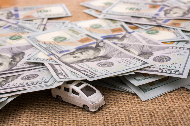 Modelo de automóvil cubierto por billetes en dólares estadounidenses
  - Foto, imagen