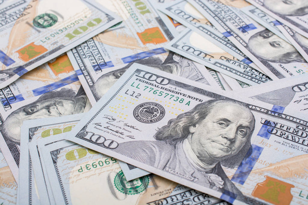 Катушка льняной катушки размещена на разбросанных банкнотах доллара США
 - Фото, изображение