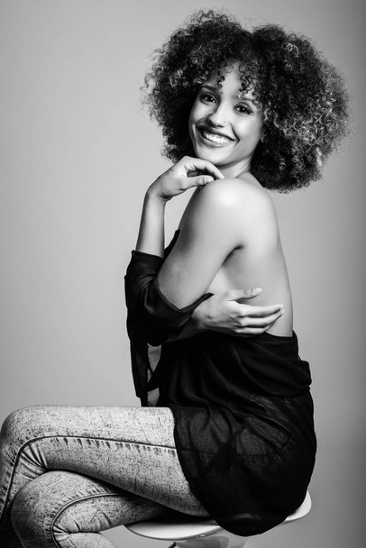 Jonge zwarte vrouw met afro kapsel lachende - Foto, afbeelding