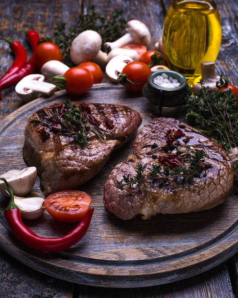  Beef Steak, salt, pepper, garlic, rosemary, olive oil, mushrooms  on the black wooden board, background. - 写真・画像