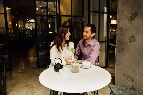 Happy couple in love in cafe on their date looking at each other and smiling - Foto, Imagen