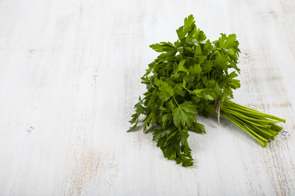 Fresh parsley on a light wooden background. - Fotó, kép