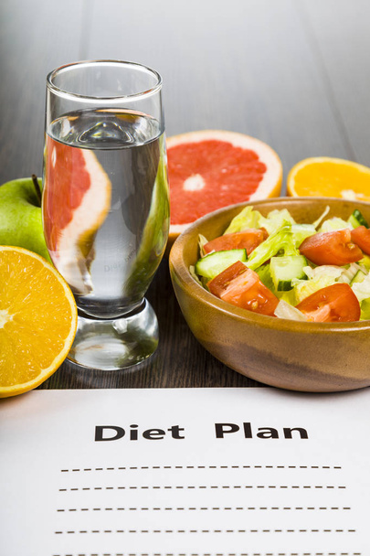 Food and sheet of paper with a diet plan on a dark wooden table. - Fotoğraf, Görsel