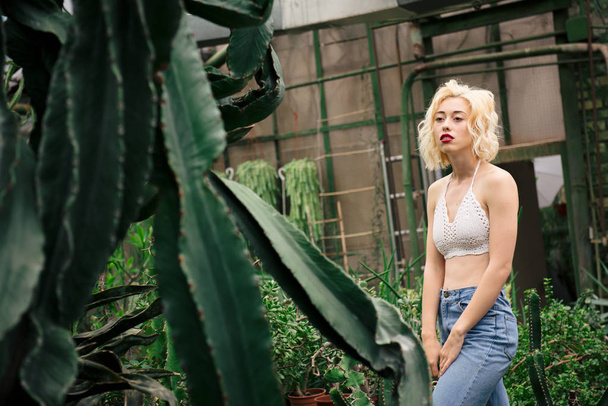schöne blonde Frau posiert im tropischen botanischen Garten - Foto, Bild