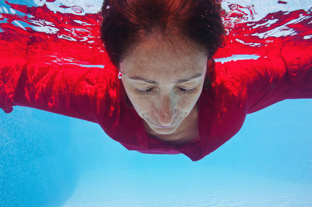 Underwater woman with red dress in swimming pool - Foto, immagini