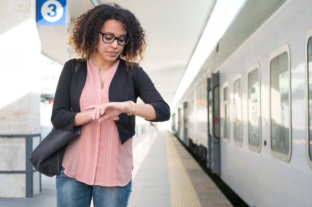 Fiatal fekete nő várja a vonat - Fotó, kép