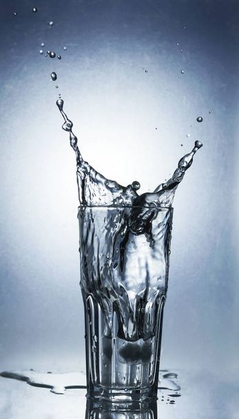 Splashing water of ice in a cool glass of water - Φωτογραφία, εικόνα