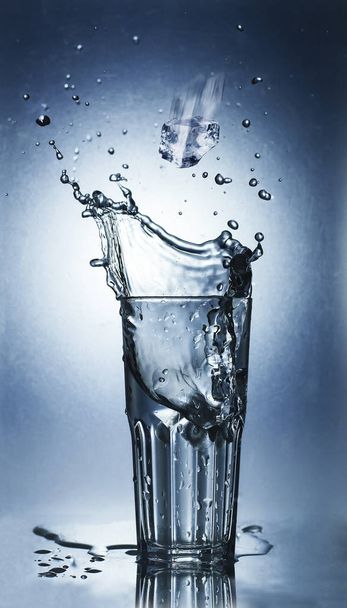 Spruzzare acqua di ghiaccio in un bicchiere d'acqua fresca
 - Foto, immagini