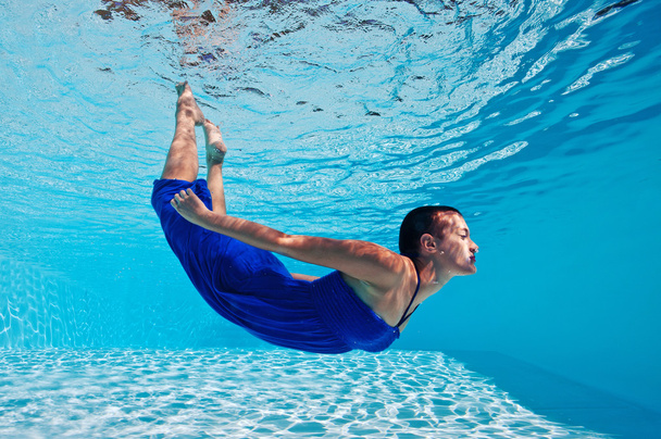 Underwater woman portrait with blue dress in swimming pool - Foto, afbeelding