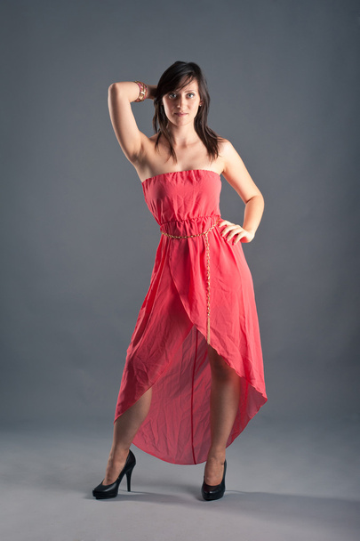 Beautiful woman in red dress on dark background - Foto, imagen