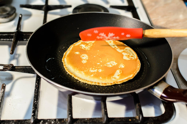 Preparation of pancakes in a frying pan. - Foto, afbeelding