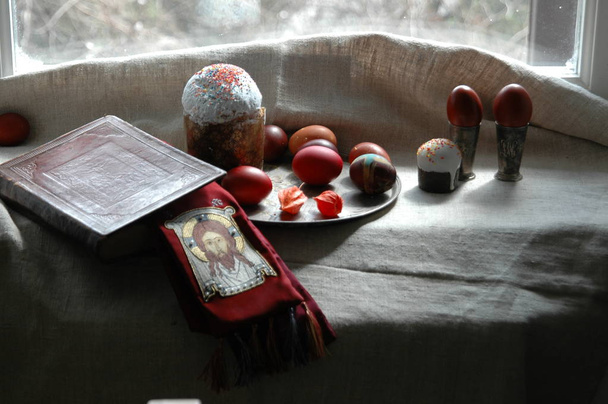 La naturaleza muerta de Pascua con la Santa Biblia, pastel de Pascua y huevos teñidos
 - Foto, Imagen