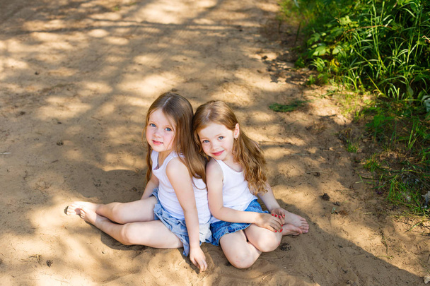 Two little girl girl friends hugging in the forest - Photo, Image