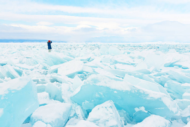 Traveller looks to a field of ice covering Baikal lake in winter. - 写真・画像