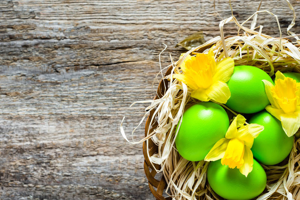 Easter background, basket with easter eggs and daffodils - Photo, image