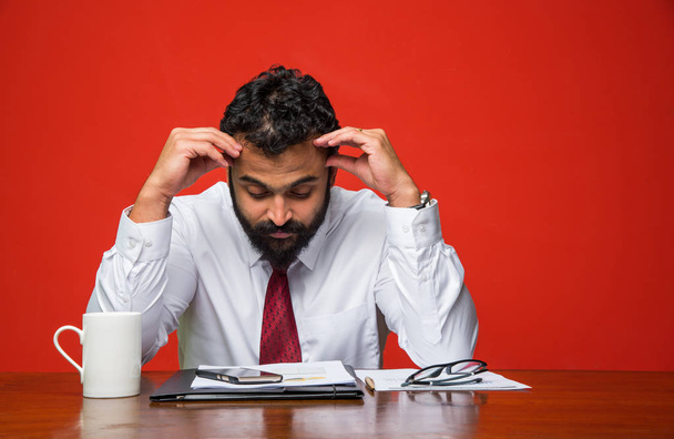 frustré jeune homme d'affaires indien avec barbe montrant des expressions tristes dans le bureau à la table de l'ordinateur
 - Photo, image