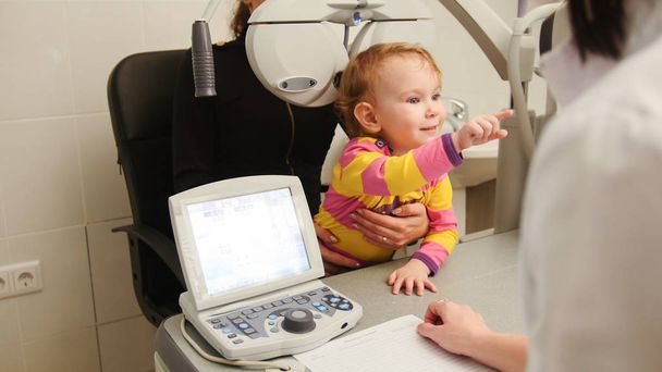 Petite fille - patiente en salle d'ophtalmologie - enfant avec maman à la consultation
 - Photo, image