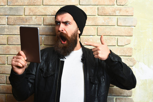 Bearded brutal caucasian hipster holding tablet - Fotó, kép