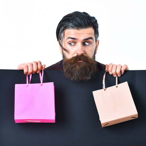 Bearded brutal caucasian hipster holding colorful package or bags - Fotoğraf, Görsel