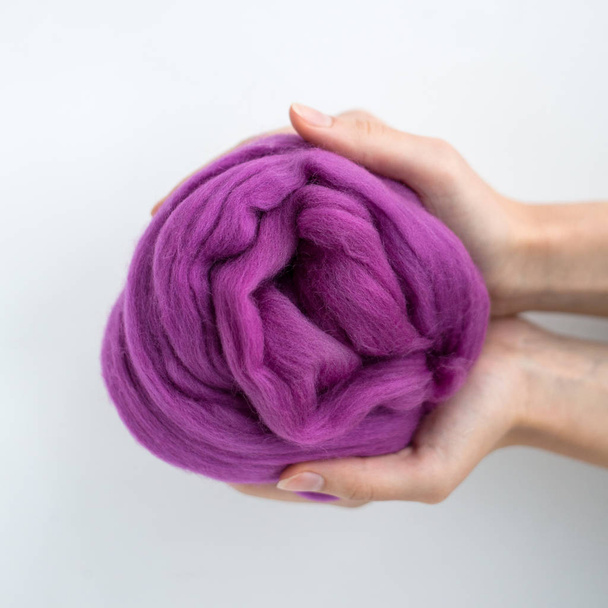 Gros plan de boule de laine mérinos violette dans les mains
 - Photo, image