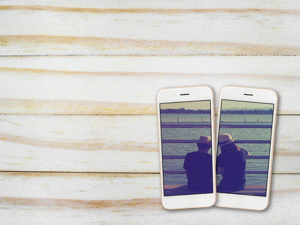 Paarfoto auf Smartphone-Bildschirm auf Holz - Foto, Bild