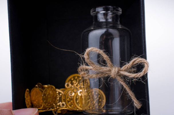 Fake gold coins and a bottle - Foto, afbeelding