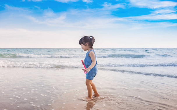 malá holčička hraje na pláži v západu slunce - Fotografie, Obrázek