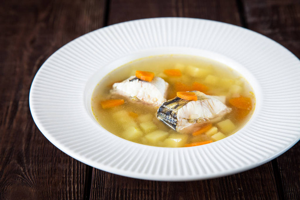 sopa de peixe fresco com poleiro de lúcio e legumes em um prato branco
 - Foto, Imagem