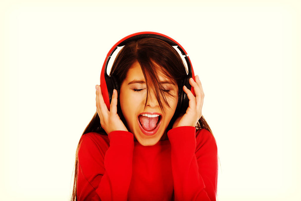 nő fülhallgató hallgató zene. - Fotó, kép