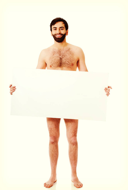 Young shirtless man holding empty banner. - 写真・画像
